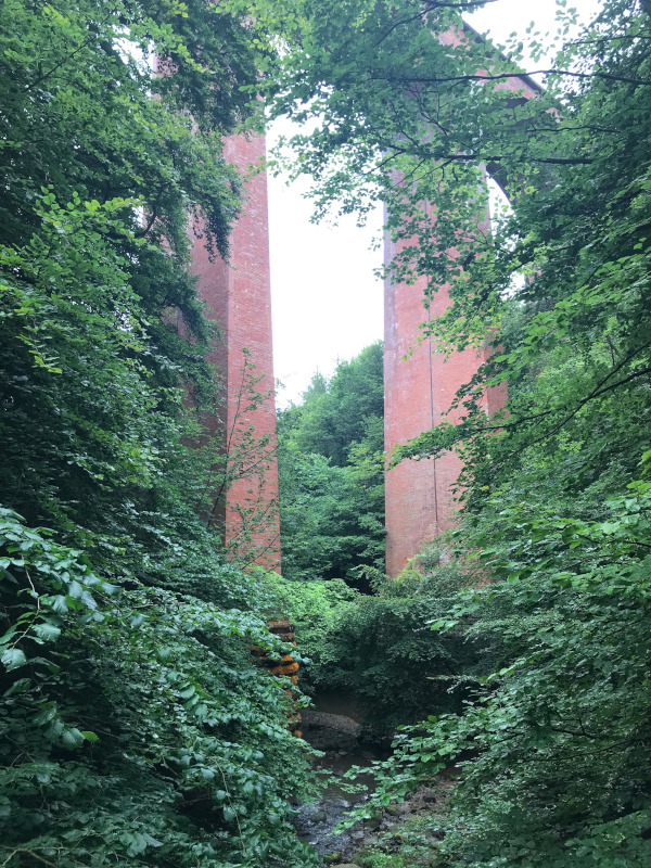 A brick built Viaduct rises high above the path.