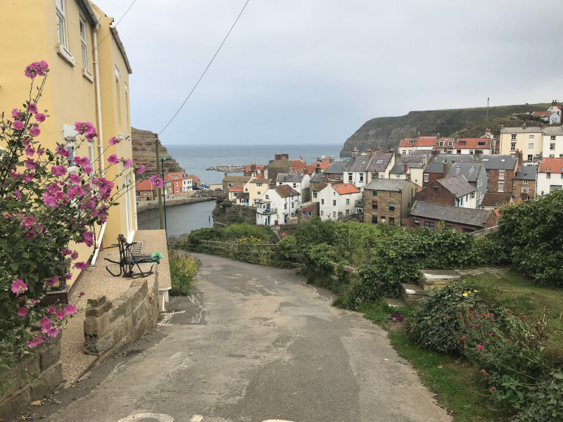Steeply sloping street leading down to a harbour.