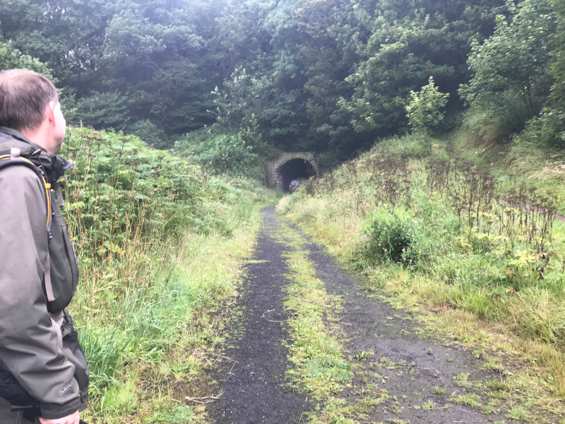B. looking back towards an old railway tunnel.