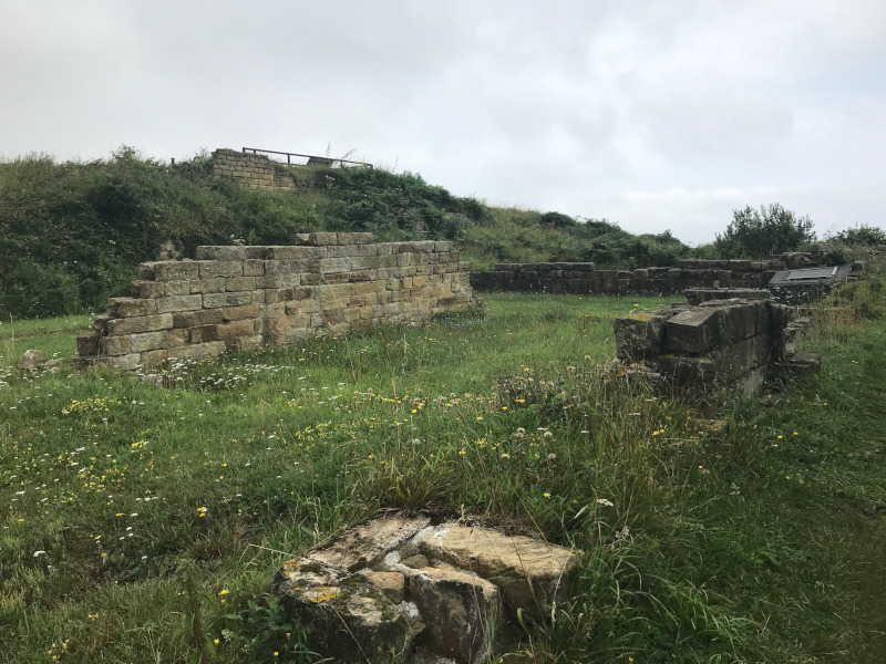 Low walls of ruined buildings in a field.