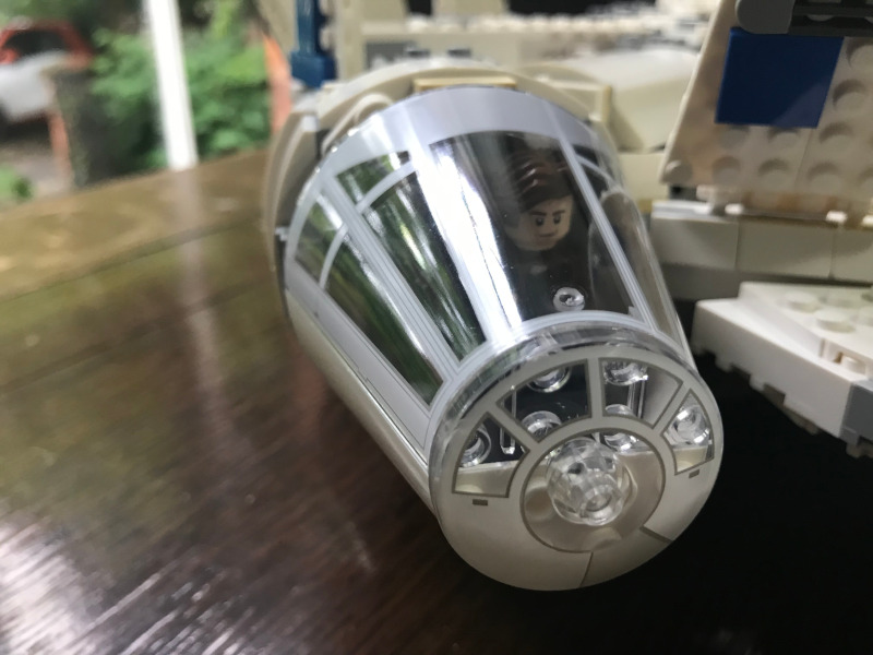 The cockpit of the LEGO Millennium Falcon. Han Solo's face is just visible through the glass.