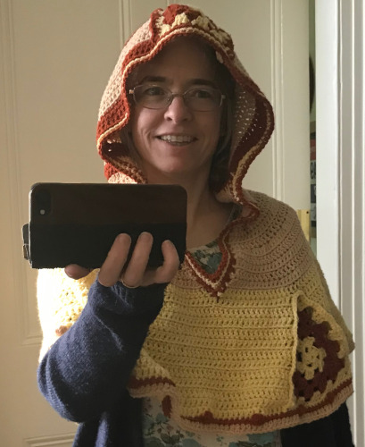 Me wearing a brown and yellow/white crocheted hood, front view close up, showing decorative triangle at breast.