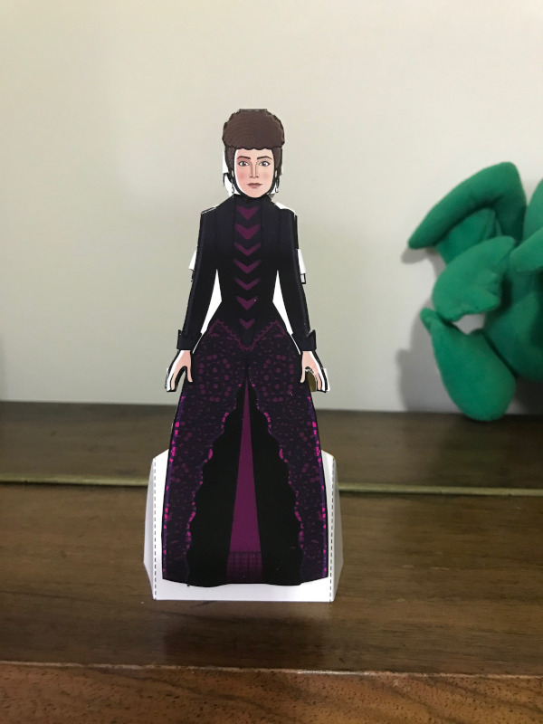 Paper Doll of Clara Oswald dressed in a Victorian style dress with her hair up.
