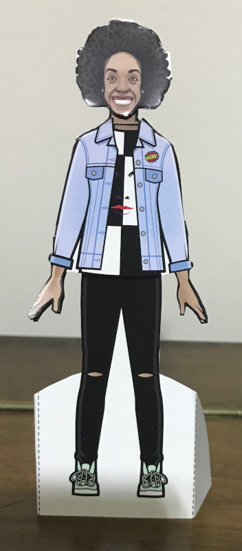 Bill paper doll with her smiling face and her black and white quartered T-shirt with a face on it and a denim jacket over the top.