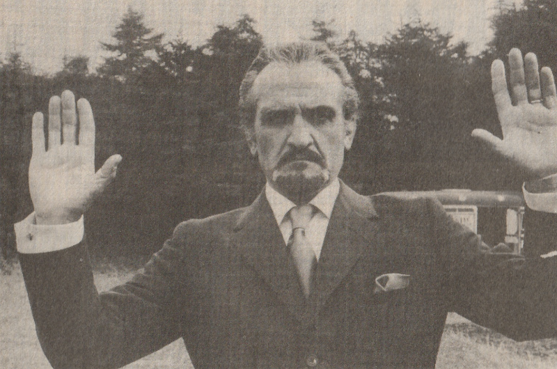 Roger Delgado as the Master with his hands up.