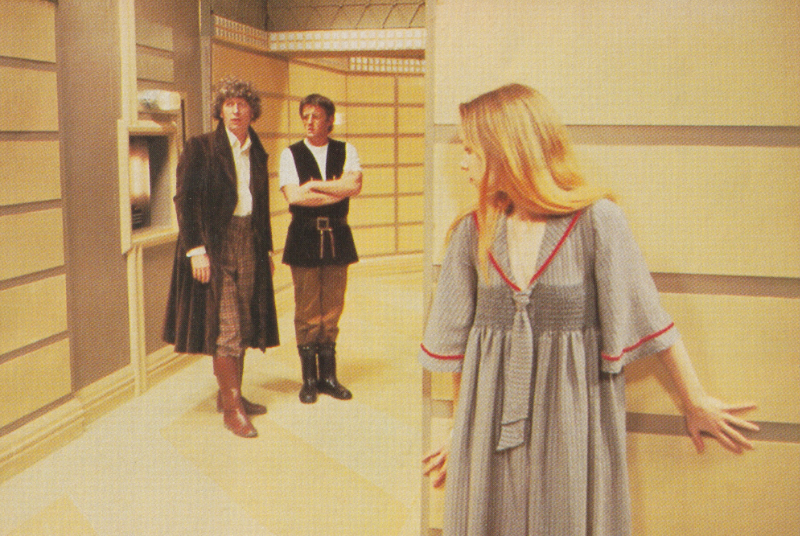 The second Romana hiding around the corner from the Doctor and another man.  From The Nightmare of Eden.