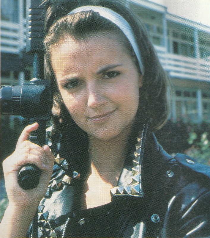 Ray from the Doctor Who episode Delta and the Bannermen. Head shot of her in biker jacket, holding a gun.