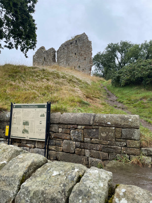 A ruined castle stands up a small hill.