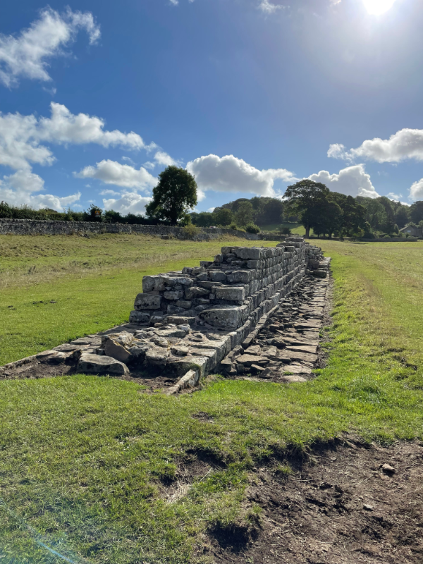 A low stretch of Hadrian\'s Wall in a field.
