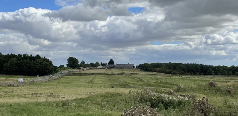 View of a field with undulating ridges showing where ditch and vallum were.