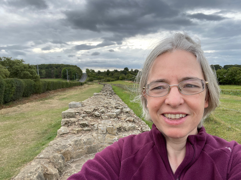 Selfie showing the wall next to a fence behind me.