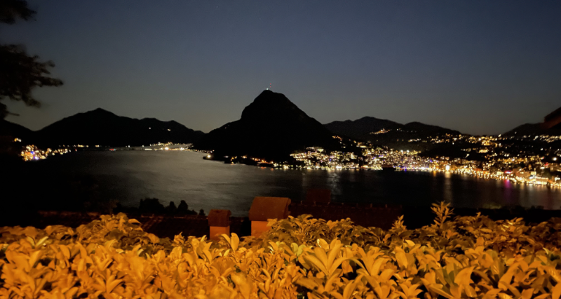 Night time view over the lake. Silhouettes of mountains beyond.