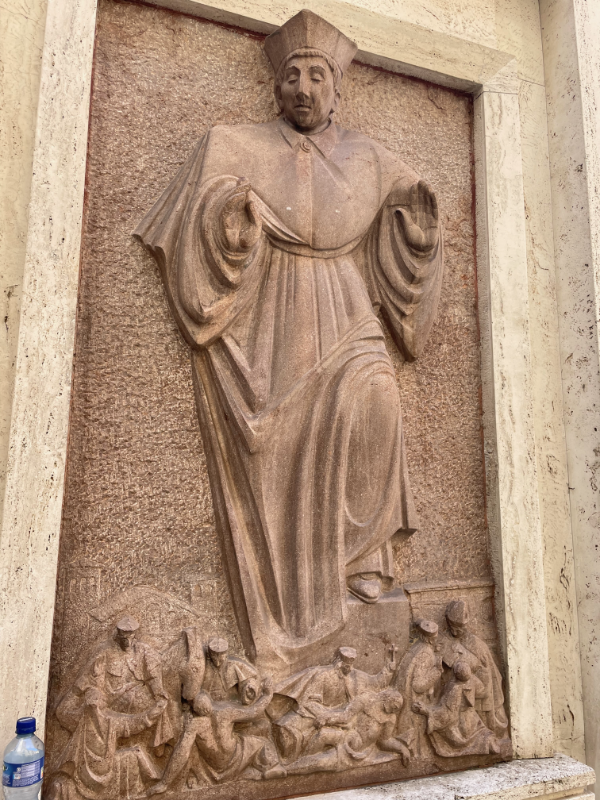 Bas Relief of an ecclesiastical gentleman who appears to be trampling unfortunates beneath his feet.