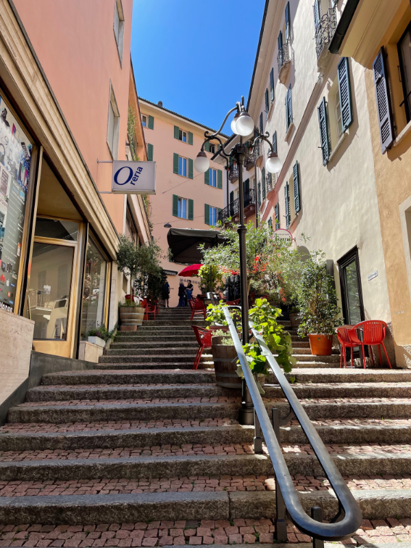 Brick steps leading up between plastered buildings.
