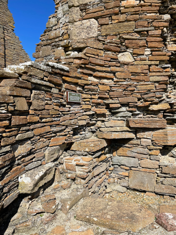 Remains of a circular tower with steps just visible going up.