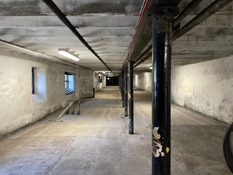 Long empty room with black pillars running down the middle