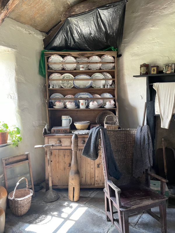 A wooden dresser with china displayed on it.