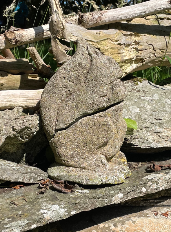 A weathered statue of a squirrel.