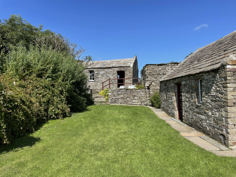 Stone buildings, some steps with a whale bone arch above.
