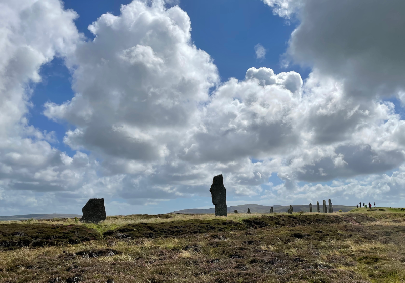 Stone circle curving away. One stone silhouetted against the sky.