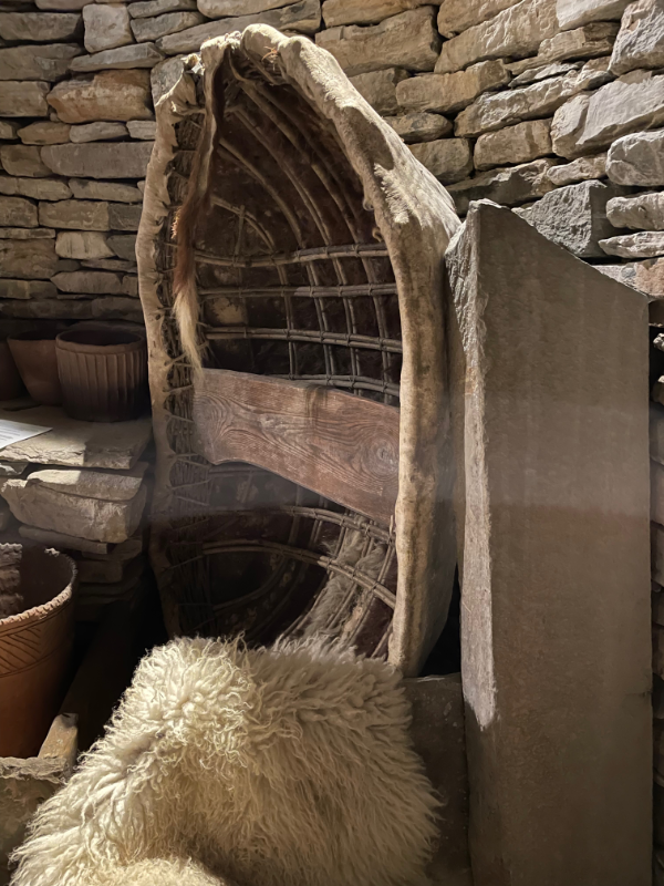 Reproduction neolithic boat against a wall.