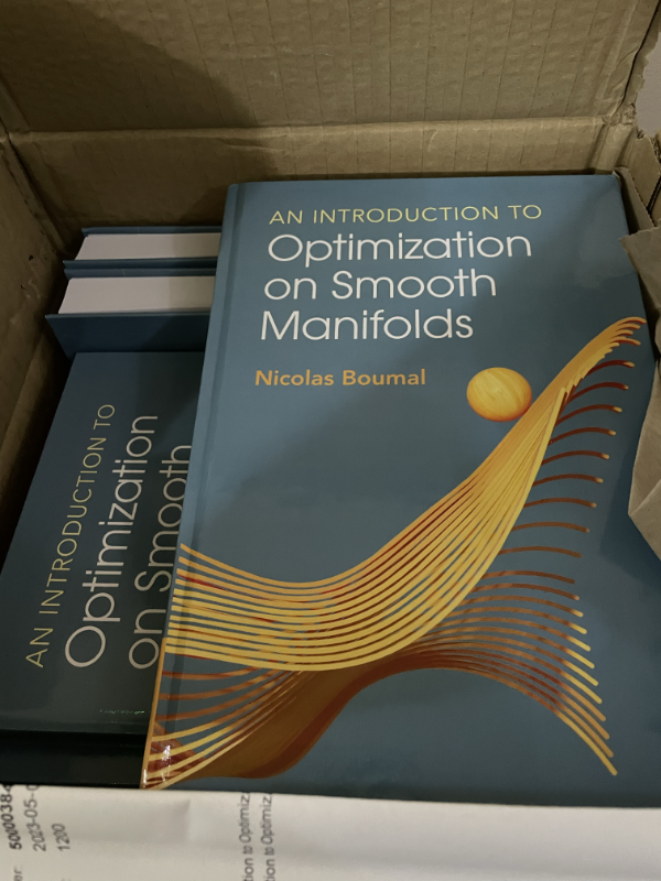 An open cardboard box containing books.  At least two are An Introduction to Optimisation on Smooth Manifolds by Nicolas Boumal.