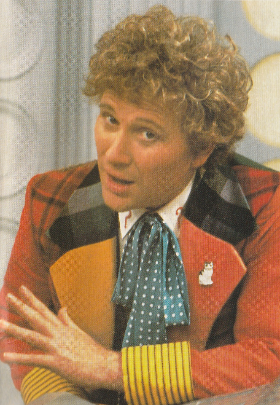 A picture of Colin Baker as the Doctor, leaning on a surface and looking at the camera.  He appears to be about to make a point.