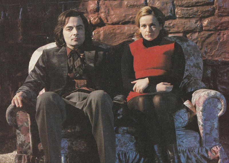 Rowan Atkinson as the Doctor and Julia Sawalha as Emma sitting on a sofa