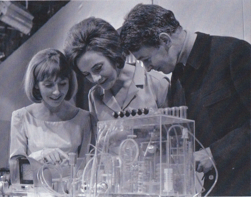 Black and White photo of Vicki, Barbara and Ian from Doctor Who all examining some kind of perspex box containing vaguely technical looking bits.