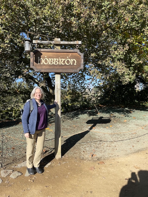 Me standing next to a Hobbiton sign.