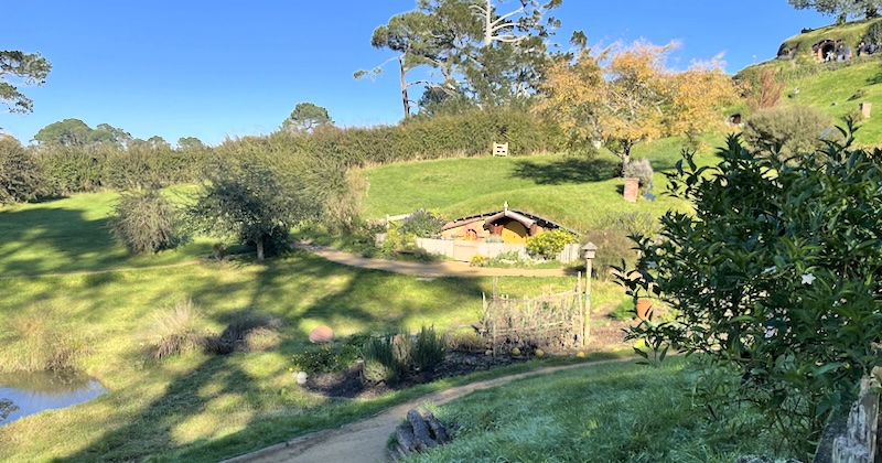 A view across a view to a hobbit hole with a yellow door.