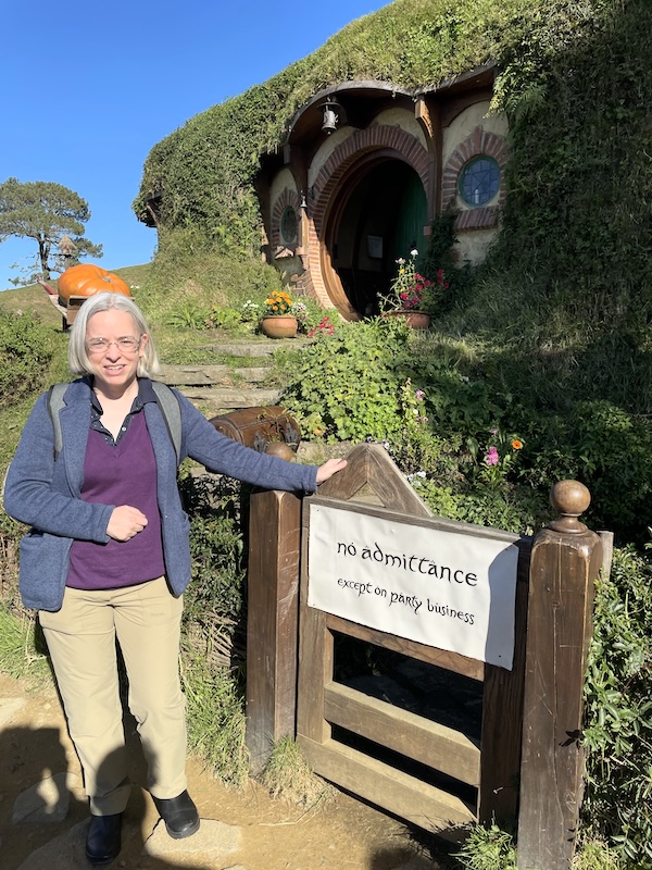 Me standing next to a gate that says No Admittance except on party business. The front of Bag End is behind me.