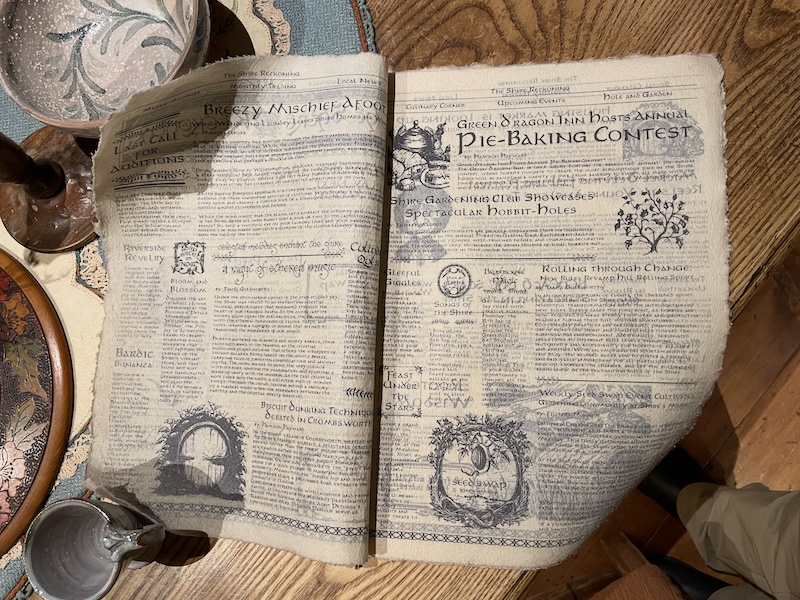 A newspaper. Headlines announce a Pie-Baking Contest and Breezy Mischief Afoot.