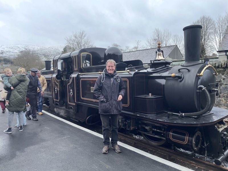 B standing next to a black steam engine.