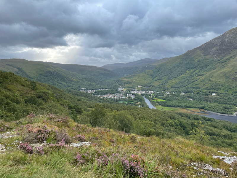 View of a small town of white houses with grey rooves nestles in a valley amid mountains