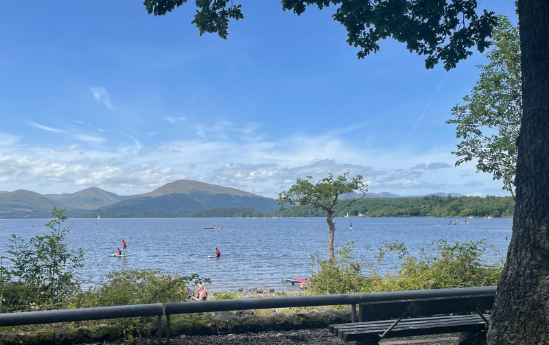 People canoeing on the Loch. Mountains in the background.