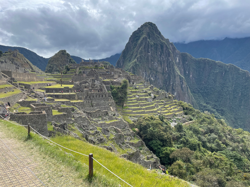 The ruined Inca city of Machu Pichu.  Stone buildings and terraces framed by the Andean mountains.