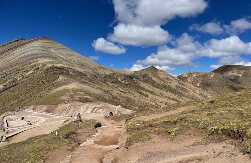 Looking down on a paved area with a kind of semi-circular ampitheatre.  Above it is a stripey mountain.