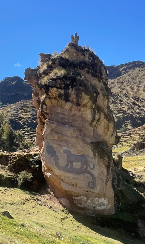 A tall rock with a silhouette of a puma riding on the back of an implausibly long snake with a strangely human-like head.  A sculpture of a condor sits on top of the rock.