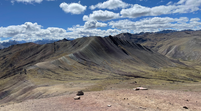 A view across to a mountain stirped in red, white and green.