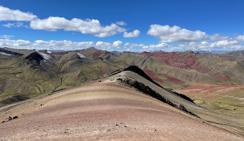 A view along a ridge path which is striped in shades of red and yellow.