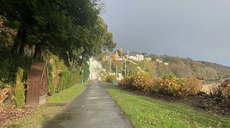 View along a straight back to the tiered, coloured buildings of Portmeirion.