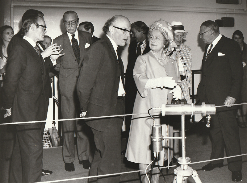 Black and White photo. Now the Queen Mum is pointing at the instrument.