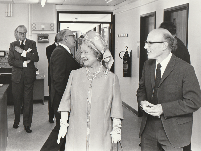 Black and White photo. I think they are leaving. Both the Queen Mum and the bald man look relieved.