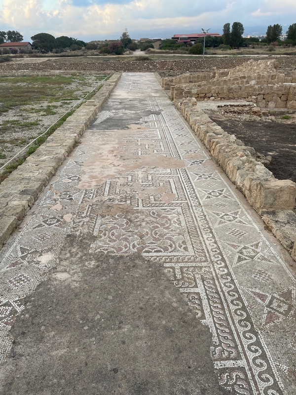 A long mosaic corridor, now out in the open.