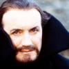 Ainley Master in a high collared cloak.