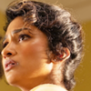 Belinda with her hair up, head only looking sideways with a concerned expression.