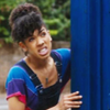 Bill from Doctor Who.  Looking around the side of the Tardis with an expression on her face.