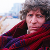 The fourth Doctor in his maroon outfit, leaning back.