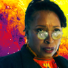 The Fugitive Doctor.  Head and shoulders wearing glasses.  Swirly purple, red and yellow pattern behind.